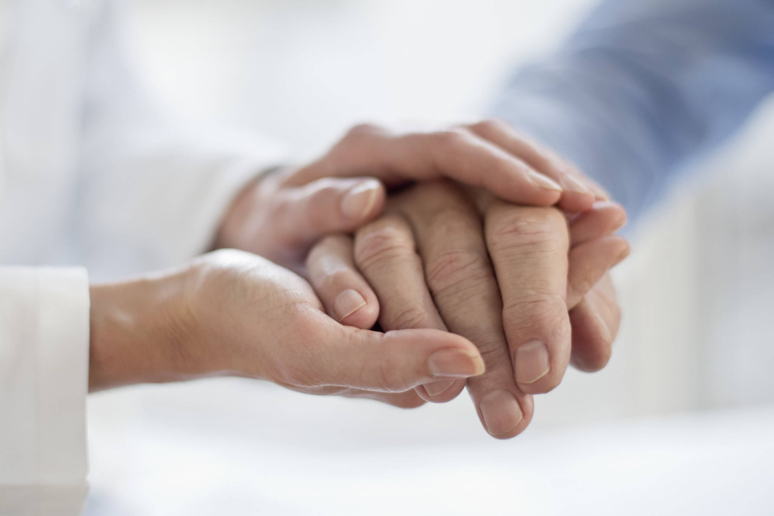Clinician and patient hold hands. Patient decision aids are a useful tool to promote healthcare equity